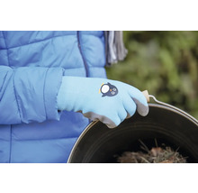 Osoba nosí záhradné rukavice s motívom tučniaka a drží vedro.