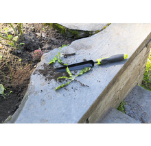 Záhradné náradie a burina na kamenných schodoch