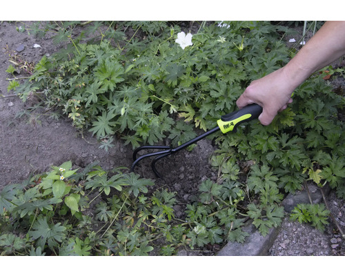 Záhradnícka scéna s osobou, ktorá používa kultivátor značky for_q na úpravu pôdy.