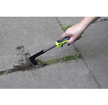 Ruka používa škrabku na škáry na odstraňovanie buriny medzi dlažobnými kameňmi.