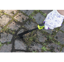 Osoba odstraňuje burinu z medzier medzi dlažobnými kockami pomocou škrabky na škáry for_q.