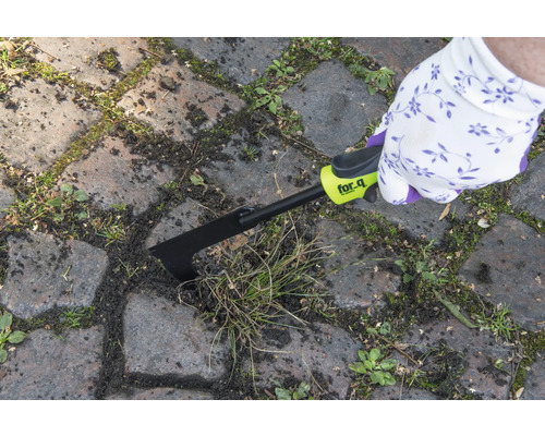 Osoba odstraňuje burinu z medzier medzi dlažobnými kockami pomocou škrabky na škáry for_q.