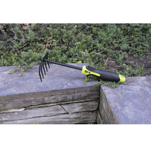 Hrabla na lístie a záhradné hrable s hrotmi a plastovou rukoväťou na kamennom múre