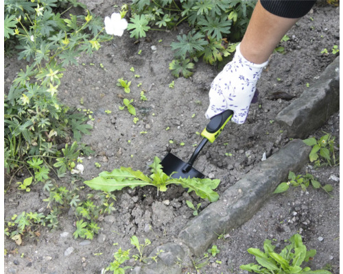 Záhradná scéna s rukou, záhradnou rukavicou a vytrhávačom buriny pri práci.