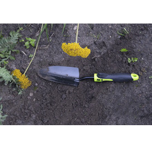 Záhradná lopatka so žltým kvetenstvom v záhradnom záhone