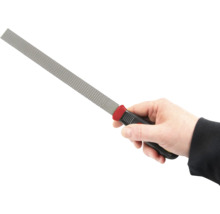 Ruka drží rašpľu s rukoväťou