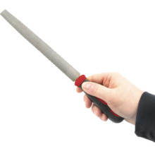 Ruka drží rašpľu s plastovou rukoväťou