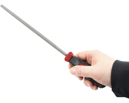 Ruka drží kľúčový pilník s plastovou rukoväťou.