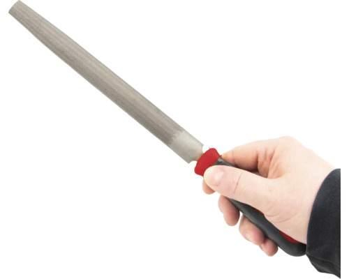 Ruka drží hladký pilník s rukoväťou