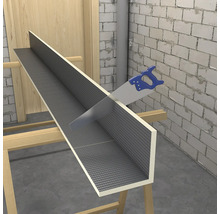 Modrá ručná píla reže stavebnú dosku v tvare L so sivým mriežkovým povrchom na drevených kozách vo svetlej, nedokončenej miestnosti.