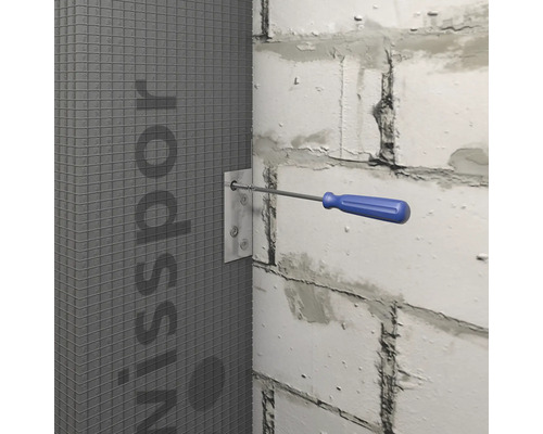 Skrutkovač upevňuje kovovú montážnu dosku na sivú stavebnú dosku na bielej stene.