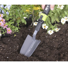 Ruka používa sadzaciu lopatku for_q na kopanie v zemine v kvetinovom záhone.