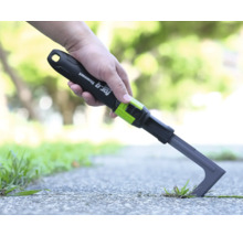 Škrabka na škáry for_q fitconnect pri odstraňovaní buriny medzi dlaždicami v záhrade.