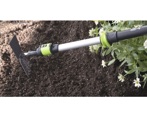 Kombinované záhradné náradie for_q s teleskopickou násadou v pôde vedľa kvetov.