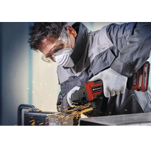 Remeselník pracuje s akumulátorovou uhlovou brúskou Einhell na kove s iskrami, má ochranné okuliare, respirátor, ochranu sluchu a rukavice.