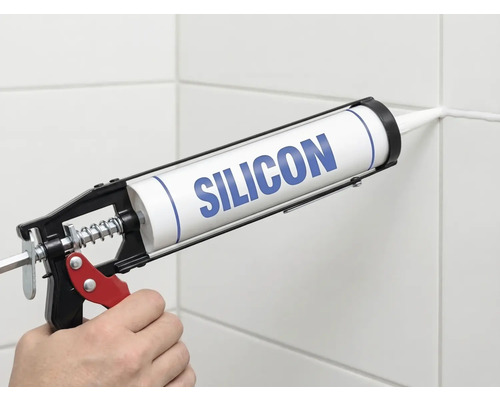 Nanášanie silikónu pomocou vytlačovacej pištole na škáru obkladu.