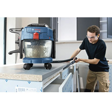 Akumulátorový vysávač na mokré a suché vysávanie Bosch pri čistení pracovného stola v svetlej dielni.