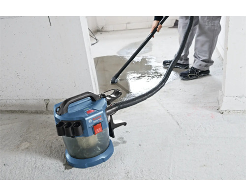 Akumulátorový vysávač na mokré a suché vysávanie Bosch Professional pri vysávaní vody z betónovej podlahy.