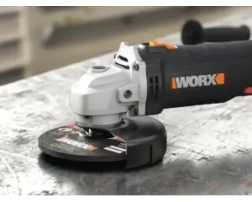 Uhlová brúska WORX s rezným kotúčom a ochranným krytom na pracovnom stole.