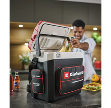 Akumulátorový chladiaci box Einhell Power X-Change v kuchyni, muž vyberá fľašu s nápojom z otvoreného boxu s vreckami na príslušenstvo.