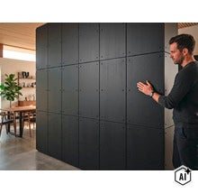 Muž sa dotýka veľkoplošného obkladu stien so štvorcovými panelmi v modernom obytnom priestore. (Image AI modified or generated)