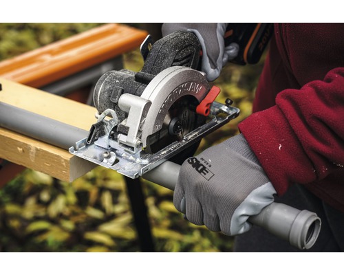 Ručná kotúčová píla reže plastovú rúrku na pracovnom stole