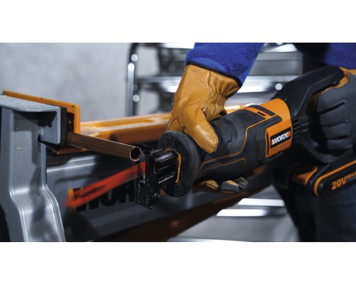 Osoba reže medenú rúrku vratnou pílou značky Worx.