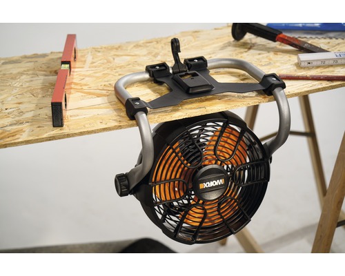 Logo Worx na staveniskovom ventilátore pripevnenom k pracovnému stolu