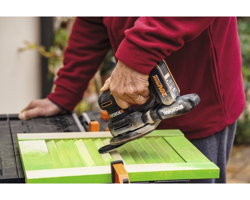 Remeselník brúsi zelené okenice pomocou akumulátorovej multifunkčnej brúsky Worx