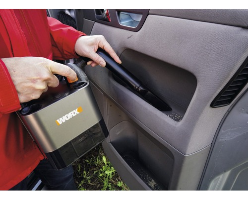 Osoba vysáva interiér auta akumulátorovým vysávačom značky Worx