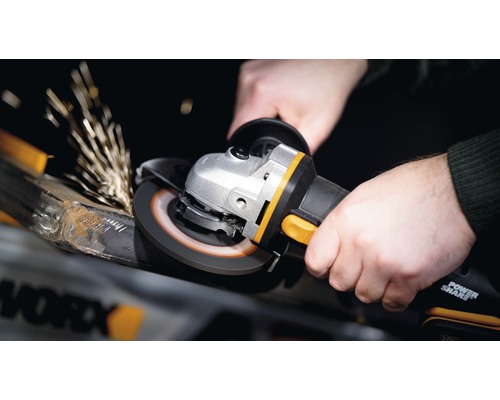 Osoba používa uhlovú brúsku na brúsenie kovu, pričom vznikajú iskry.