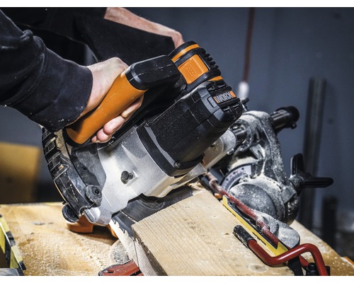 Kapovacia a pokosová píla reže drevený obrobok. Logo Worx.