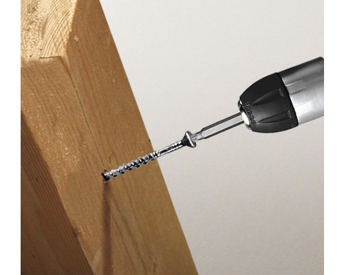 Skrutkovač skrutkuje skrutku do kusa dreva