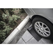 Nájazdový klin pod pneumatikou auta na dlažobných kockách