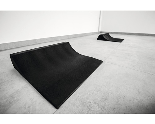 Dve čierne skateboardové rampy na dlaždenej podlahe