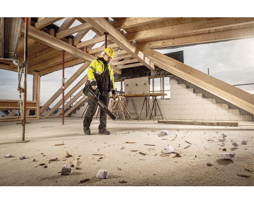 Robotník používa fúkač lístia Metabo na stavenisku na odstránenie nečistôt a pilín.