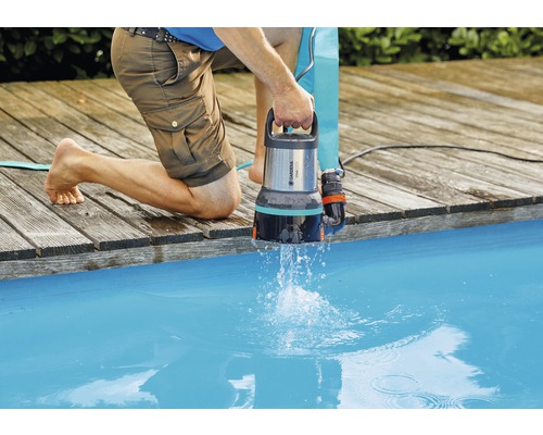 Muž vypúšťa vodu z bazéna pomocou kalového čerpadla Gardena.