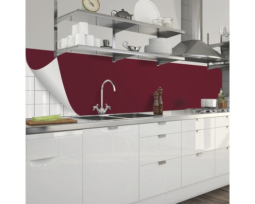 Kuchynská scéna s červenou kuchynskou doskou, drezom a bielymi skrinkami.