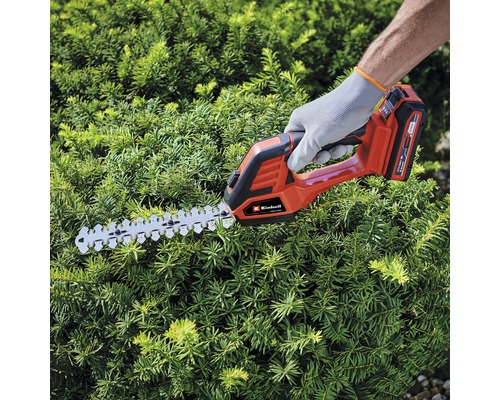 Osoba strihá živý plot pomocou akumulátorových nožníc na živý plot Einhell.