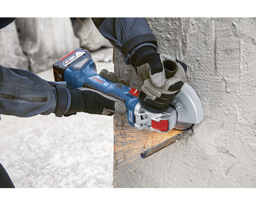 Akumulátorová uhlová brúska používaná pri rezaní ocele v betónovej stene