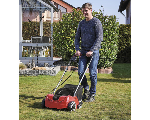 Muž používa prevzdušňovač trávnika v záhrade.