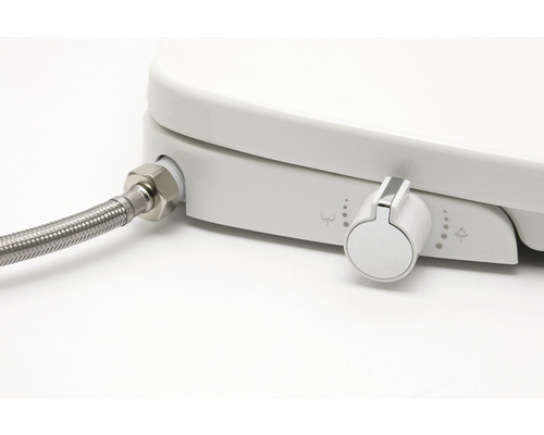 Detailný záber sprchovacieho WC sedadla s prípojkou vody a ovládacím gombíkom.