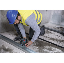 Remeselník používa laserovú vodováhu na vyrovnanie kovovej lišty