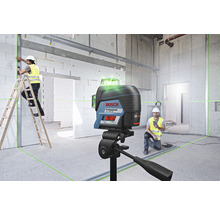 Stavenisko s rotačným laserom, pracovník na rebríku a logo Bosch