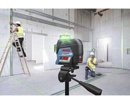 Stavenisko s rotačným laserom, pracovník na rebríku a logo Bosch