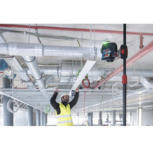 Interiérový záber staveniska s pracovníkom a čiarovým laserom na vyrovnanie