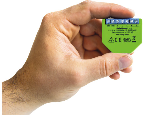 Ruka drží stmievač Shelly Dimmer 2 pre domácu automatizáciu