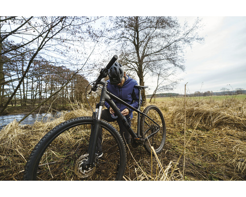 Muž opravuje bicykel v prírode
