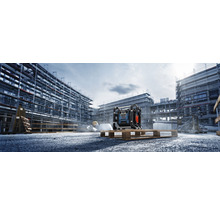 Stavebná scéna so stavebným rádiom na palete pred hrubou stavbou