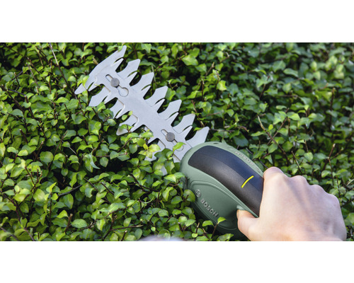 Akumulátorové nožnice na živý plot v prevádzke na živom plote. Logo Bosch.